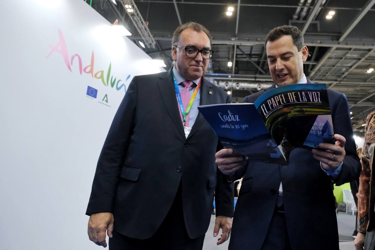 Edición especial de 'El Papel de La Voz' por la World Travel Market 2022. En la imagen, el presidente Moreno y el consejero Bernal hojean la revista impresa de lavozdelsur.es.