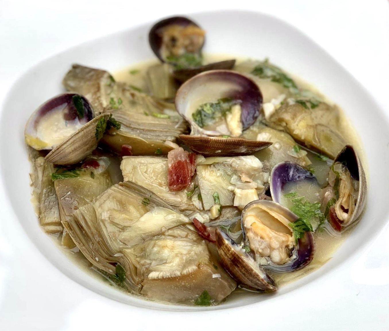 Receta de alcachofas en salsa con almejas y jamón.