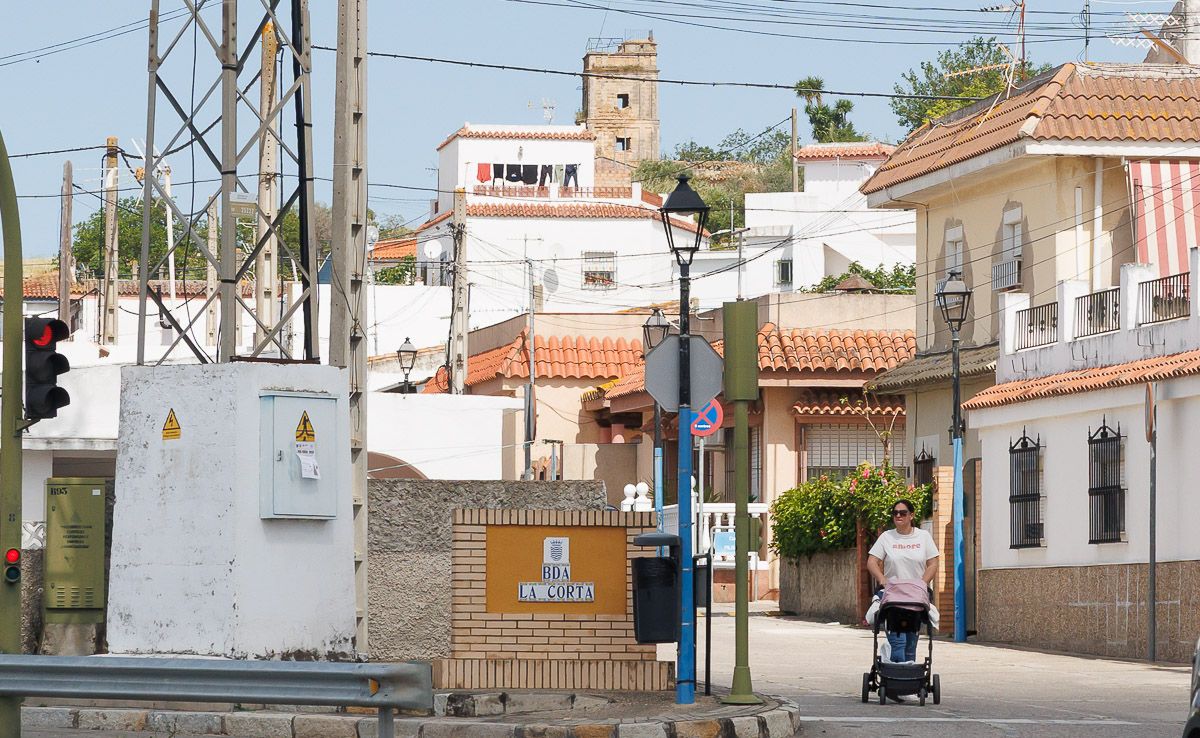 Un vecina pasea a su bebé por la calle principal de La Corta, barriada rural de Jerez. 